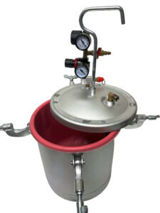 Aluminum pressure pot with gauges and a red interior for spray painting applications.